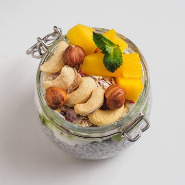 Hindistan cevizi sütü, mango ve fındık ile kavanozda Chia tohum puding