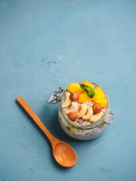 Chia zaad pudding in pot met kokosmelk, mango en noten — Stockfoto