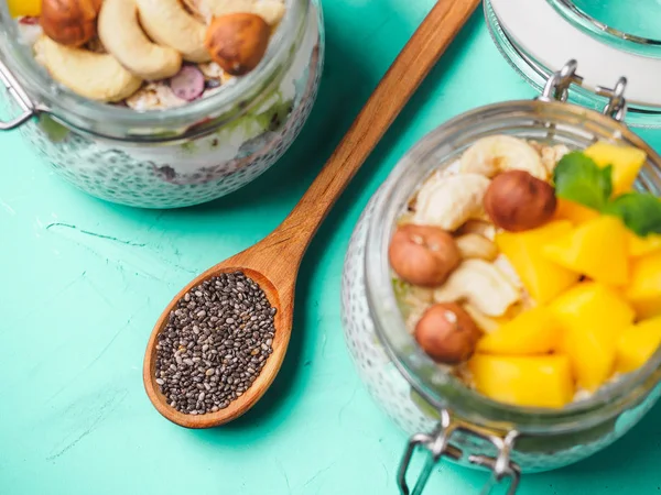 Chia seed pudding in jar with coconut milk, mango and nuts — Stock Photo, Image