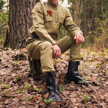 Ormanda Sovyet savaş üniforması giyen bir adam. Zafer günü canlandırma