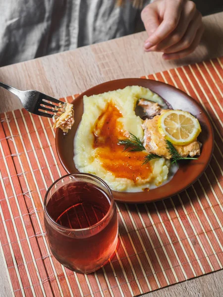 Fried fish with mashed potato and tea. Cafe table