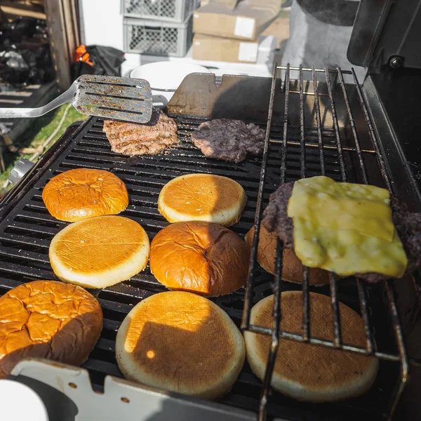 Cozinhar hambúrgueres com carne de vaca na grelha bbq festival de rua — Fotografia de Stock