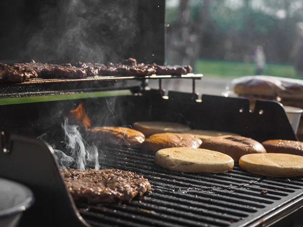 Cooking burgers with beef meat in grill bbq street festival — Stock Photo, Image