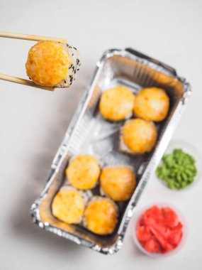 Sıcak peynir, ahşap çubuklarla dolu folyo kabında yuvarlanıyor..