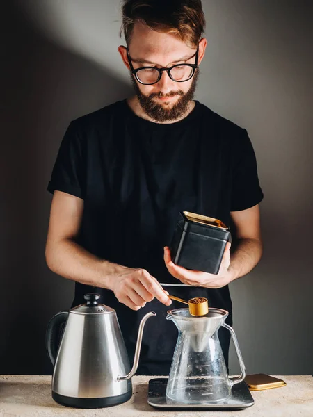 Making filter coffee with kettle for brewing by man.