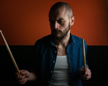 Çocuk kot gömlek ve koyu arka plan ile davul çalmaya