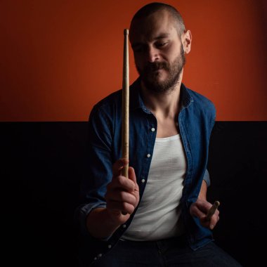 Çocuk kot gömlek ve koyu arka plan ile davul çalmaya