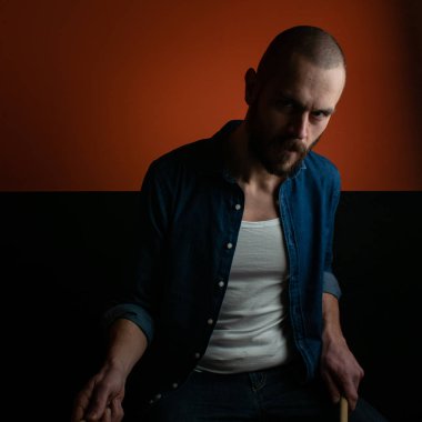 Çocuk kot gömlek ve koyu arka plan ile davul çalmaya