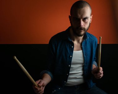 Çocuk kot gömlek ve koyu arka plan ile davul çalmaya