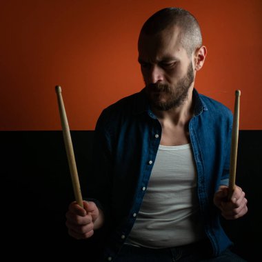 Çocuk kot gömlek ve koyu arka plan ile davul çalmaya