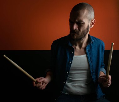 Çocuk kot gömlek ve koyu arka plan ile davul çalmaya