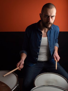 Çocuk kot gömlek ve koyu arka plan ile davul çalmaya