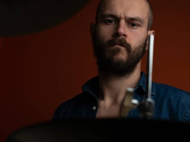 Çocuk kot gömlek ve koyu arka plan ile davul çalmaya