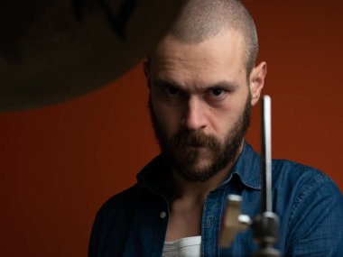 Çocuk kot gömlek ve koyu arka plan ile davul çalmaya