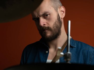 Çocuk kot gömlek ve koyu arka plan ile davul çalmaya