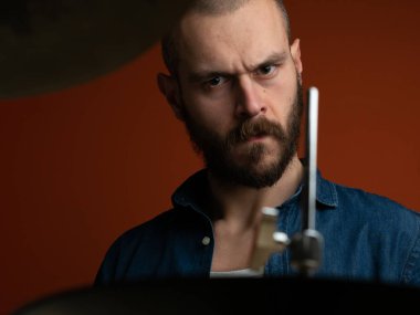 Çocuk kot gömlek ve koyu arka plan ile davul çalmaya