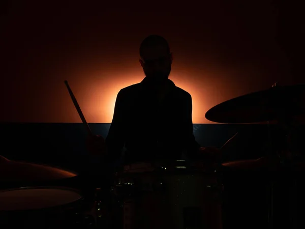 Boy playing drum with backlight