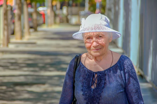 Close-up portret van oudere vrouw staand buiten in de zomer — Stockfoto