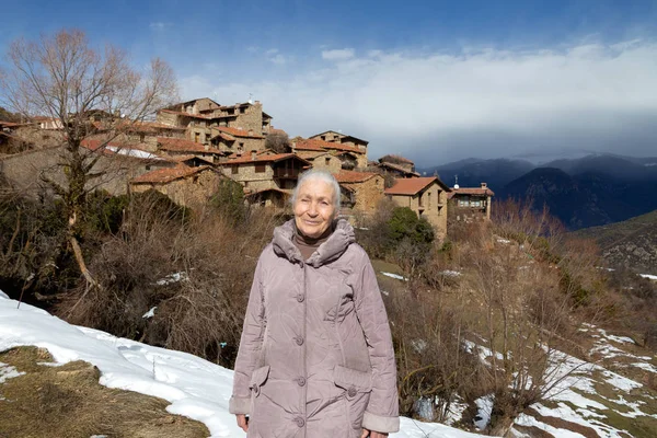 Старшая женщина наслаждается весенним пейзажем в горной деревне . Стоковая Картинка