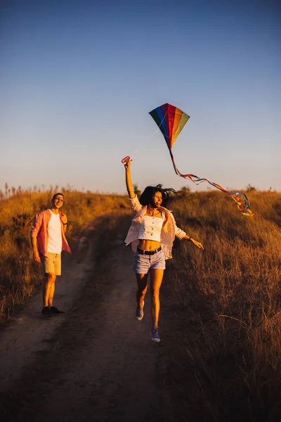 Young couple have fun with kite. they send Genuine emotions to the world.