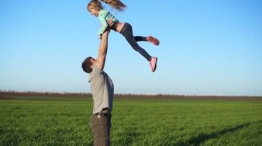 Ağır çekim bir yakışıklı genç baba çok güzel kızı hava atma. Aktif bir yaşam. Güzel yeşil alan