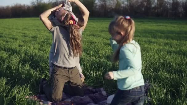 Genç bir anne-baba bir çöp üzerinde bir çayırda yetişkin kızları oynuyor. Omzunun üzerinden geçmiş bir fırlatıyor. Genç bir şakacı daddys geri atlama. Ağır çekim — Stok video