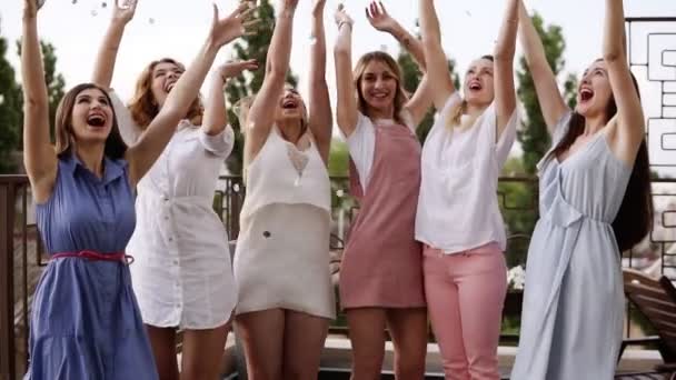 Stijlvolle meisjes op bachelorette partij buiten op het terras. Zilveren confetti in de lucht gooien. Gelukkig levensstijl, genieten van het leven. Dansen en lachen. Overdag. Slow motion — Stockvideo