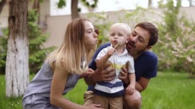 Genç, Çift zaman oğulları ile ayırın. Babası elleriyle bir sakal tutan çocukla. Annesi ile birlikte, onlar dandeliond üfleme vardır. Yeşil renk, çim