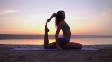 Denize yakın bir hasır üzerinde egzersiz çekici yogi kadın. Ofyoga duruş karıştırın. Sabah alacakaranlıkta