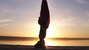 Güzel bir kız ayakta görüntülerini yakından yoga asana kafasına beklemiştik. Güneş parlıyor ve su arka planda