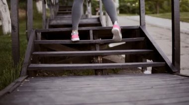 Gri tozluk merdiven yüksek sıçramaları ve geniş ayakları üzerinde atlama bir womans kaslı bacakları kapatın. Açık havada. Park