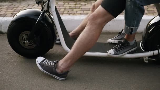 Tedere, zachte Wang kus van een jonge vrouw naar haar vriendje. Paar zitten op een fiets in het park. Trendy soortgelijke kleding dragen — Stockvideo