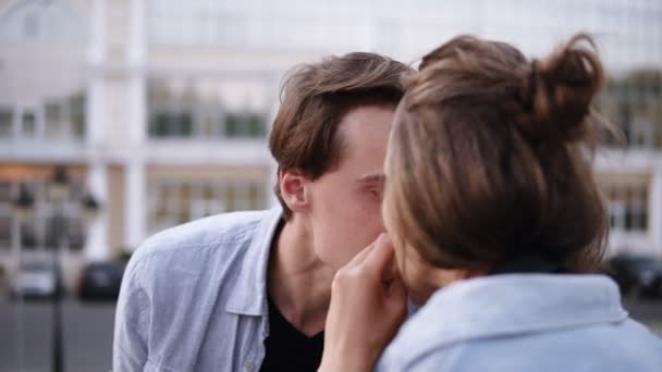 Preciosa pareja joven están comiendo una hamburguesa juntos.Amar a los jóvenes al aire libre. Usando camisas azules. Buenas tardes. Lado del parque — Vídeo de stock