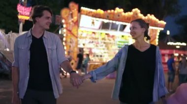 Romantik bir eğlence parkında kalma. Lunapark tarafından geceleri yürüyen genç bir çift. Kız bir pamuk şeker tutarak ve eğleniyor, onun erkek arkadaşıyla dans. Ağır çekim