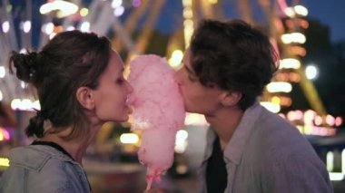 İki hipsters lunapark içinde gece kalma. Pamuk şeker birlikte yeme, gülümseyen birlikte, eğleniyor. Benzer kıyafetlerle