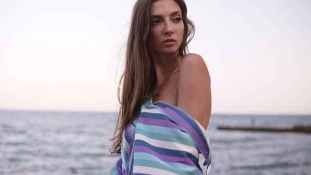 Vacker brunett sexig sätter på en siden klänning på hennes axel, ser sensuellt på kameran. Seaside, mode, sommar koncept — Stockvideo