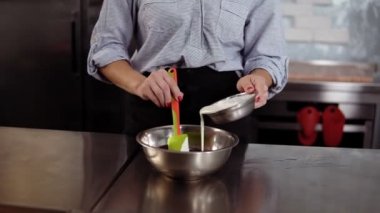 Sevgilim önlük kadında onun mutfak dökme krem Paslanmaz bir kabın içinde bir pasta malzemeleri karıştırma. Mutfak, mutfak konsepti