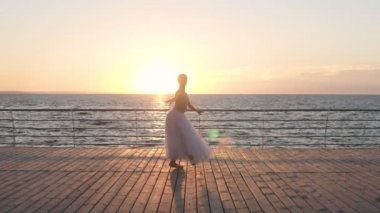 Zarif kız denize sıfır, ağır çekim, kaldırımda bale pratik pirouettes yapar. Sabah