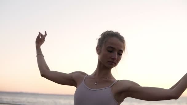 Une gracieuse ballerine dansant des éléments de ballet à l'extérieur avec la mer sur le fond. Danse de ballet caucasienne en tutu blanc, fille en pointe — Video