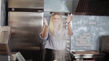 Genç kadın pudra şakacı Alkışlar eller ile un, hamur kneads. Mutfak, mutfak, pasta kavramı. Modern, gri renkli mutfak