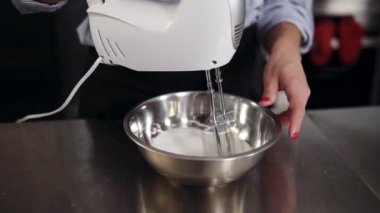 Kasede beyaz yumurta krema kek, tatlılar kavramı motor mikser ile karıştırma bir sürecin kapatın. Modern stüdyo, kadın pudra