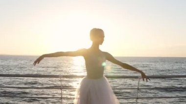 Açık havada pratik balet muhteşem silüeti. Güneş ışınları beyaz tutu duran kız. Seaside