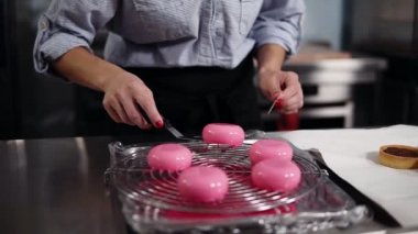 Mutfak, pasta, küçük iş kavramı. Kadın pudra lezzetli, modern tatlı hazırlanıyor. Pembe buzlu kek çikolata krema ile doldurulmuş taltles koyarak. Yakın çekim