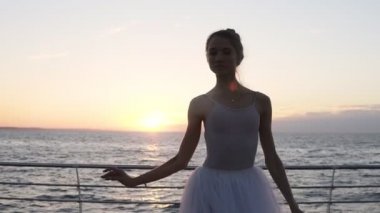 Sabah güneş ışınlarının bir tutu zarif bir balerin önden görünümü. Egzersizleri, pratik, klasik pas yapıyor. Sabah alacakaranlıkta