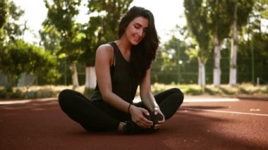 Atletik kadın onun hamstring uzanan bacaklar egzersiz eğitim fitness egzersiz dışında önce stadyum üzerinde yaz sabahı. Açık havada