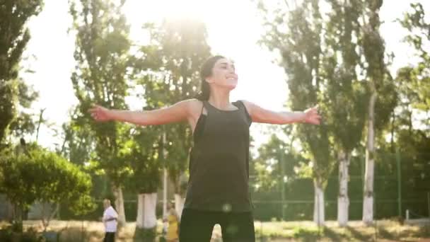 Fitness, sportliche Frau, die draußen im Stadion trainiert. glückliche brünette Frau macht Jumping Jack oder Star Jump Übung im Freien — Stockvideo
