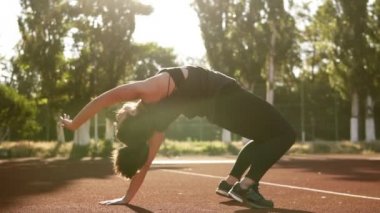 Uygun kadın pozisyon oturan köprü poz yoga egzersiz yapmak. Esneklik eğitim kasları egzersiz esmer beyaz kadın. Açık havada Stadyumu