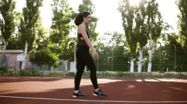 Happy, smilingfit kız spor giyim performingwheel egzersiz. Bir küçük açık havada stadyum üzerinde çalışma dışarı. Güneş ışığı, yeşil ağaçlar arka planda