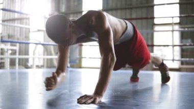 Yakışıklı genç kaslı sporcu şınav ya da spor salonunda dışarı çalışırken tahta egzersiz yapıyor. Yukarı ve aşağı dirsek için gelen uzanmış eller