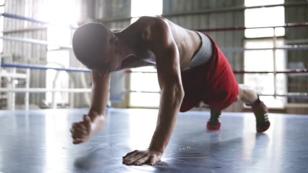 Knappe jonge gespierde sportman doet push-ups of plank oefening tijdens het trainen in de sportschool. Op en neer van de ellebogen naar uitgestoken handen — Stockvideo